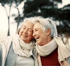 Friends together outdoors, dressed warmly in scarves and sweaters.