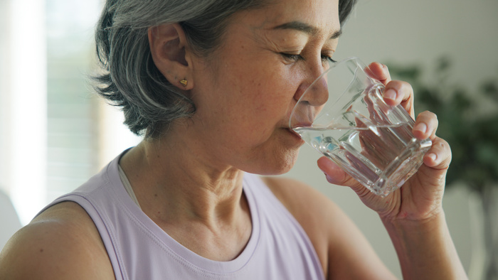 Close up senior woman sipping water from glas-1