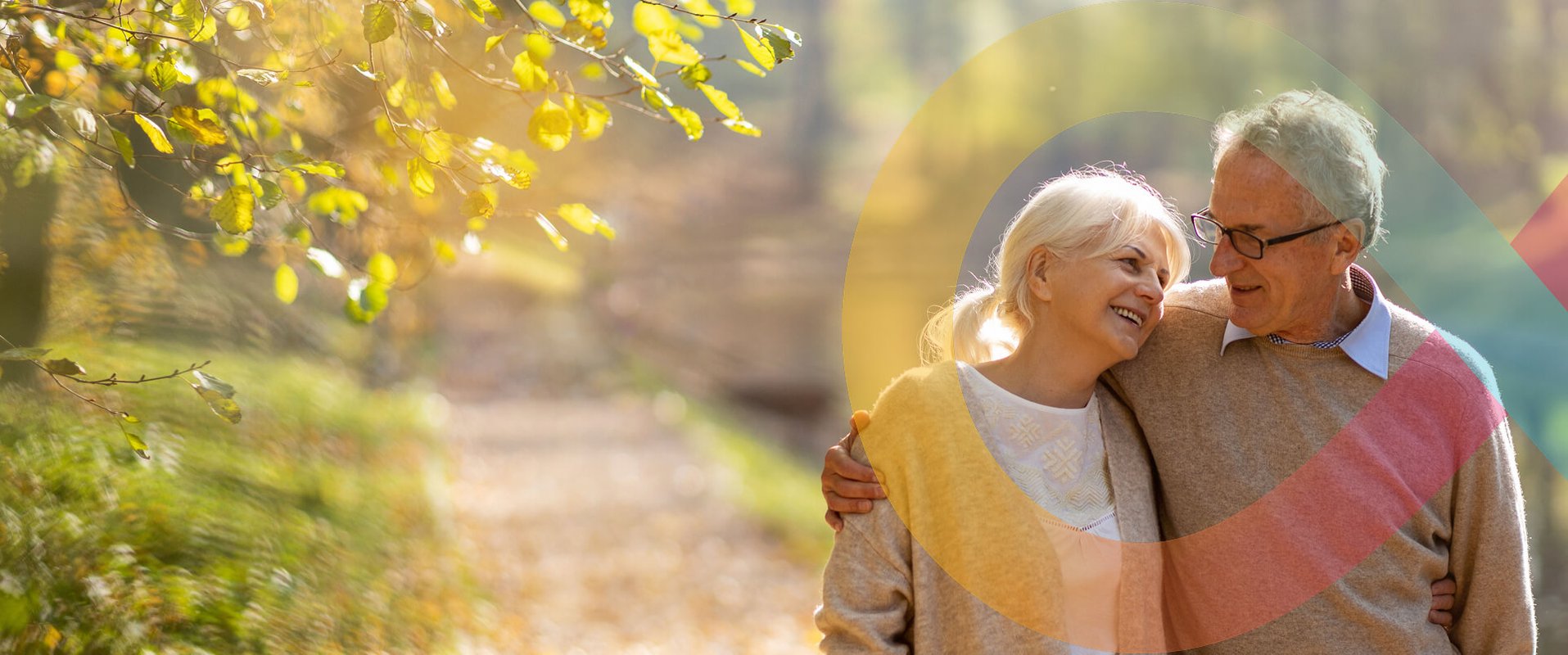 Couple smiling and embracing on a sunny forest path