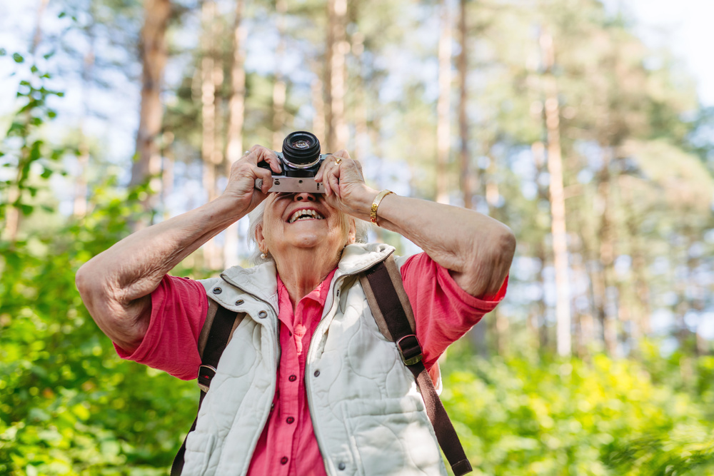 Smiling woman taking photo on nature walk