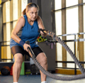 focused older woman exercising using battle ropes in gym-1-1-1-1