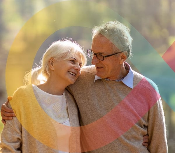 Couple smiling and embracing on a sunny forest path